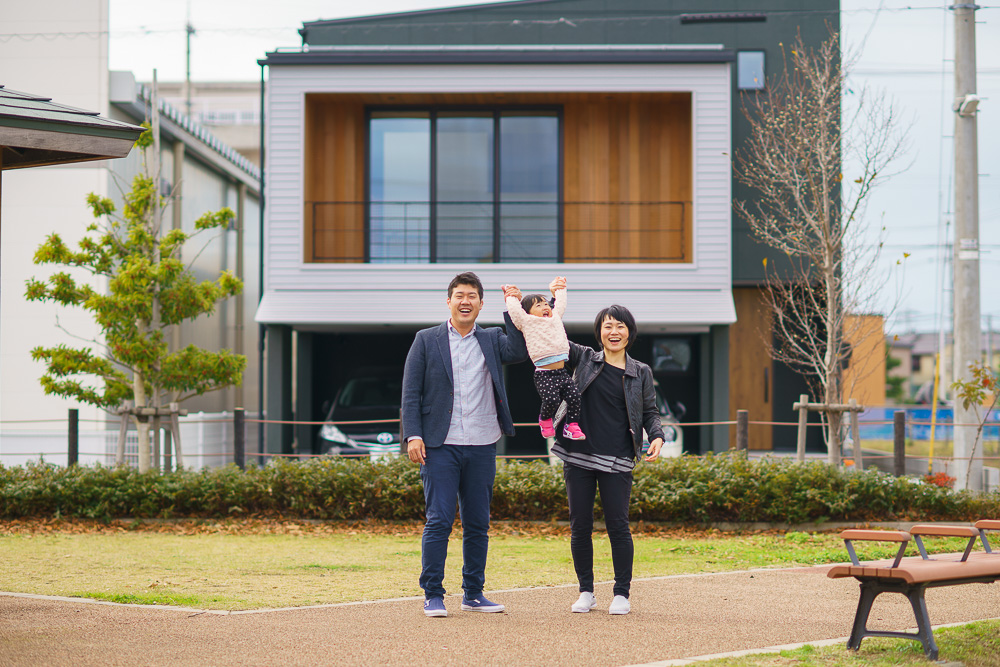 新築した家の前で記念撮影する親子