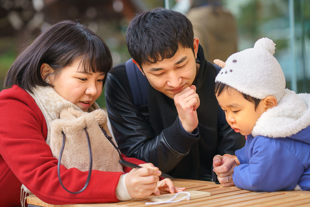 尾山神社で七五三に絵馬を書く親子