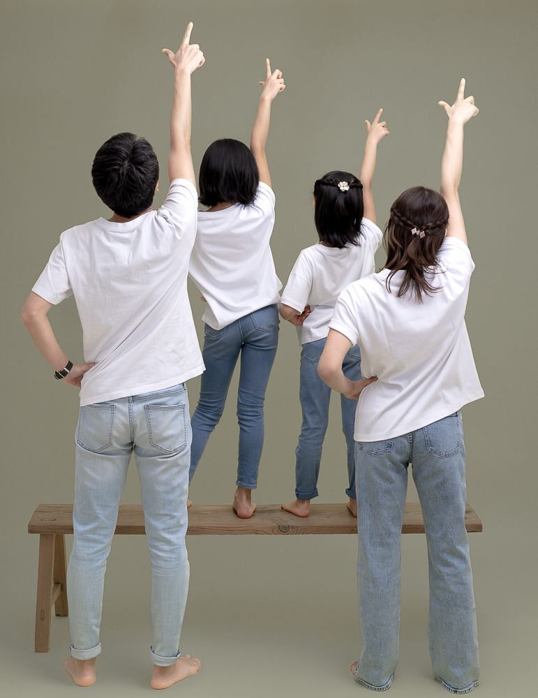 スタジオでグレー背景紙で手をあげる親子