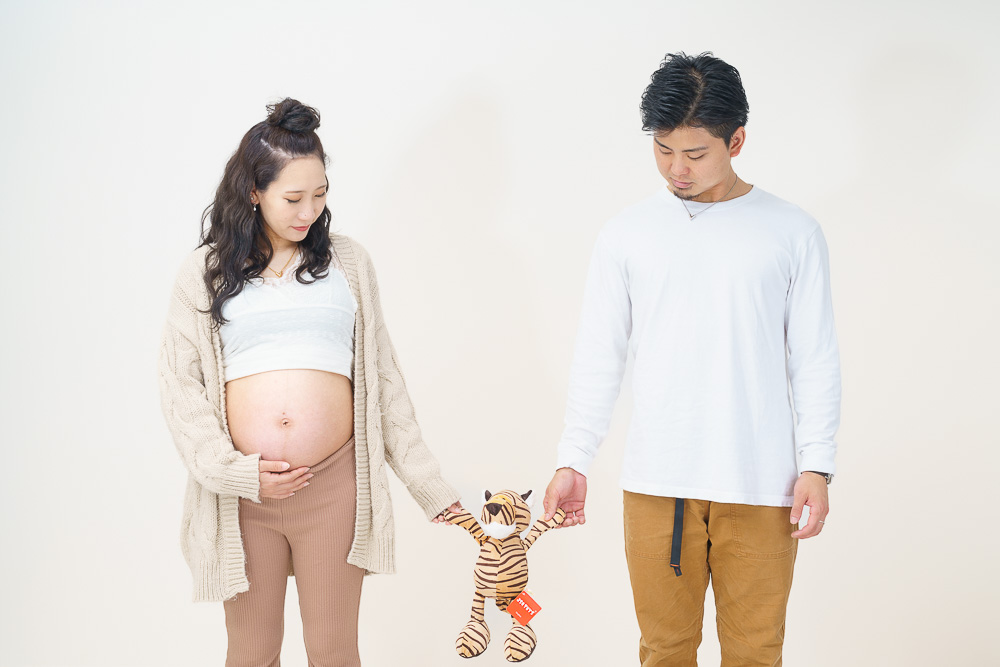 トラの人形を持つ妊婦と夫