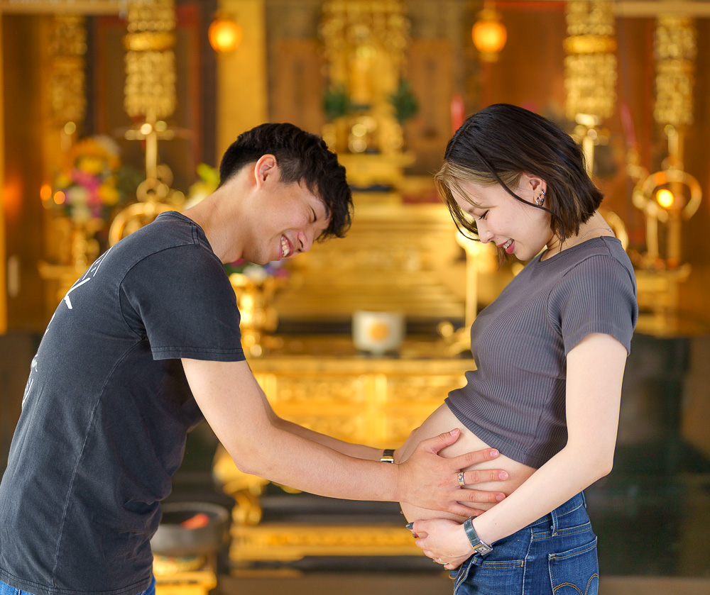 仏前妊婦のお腹を触る夫