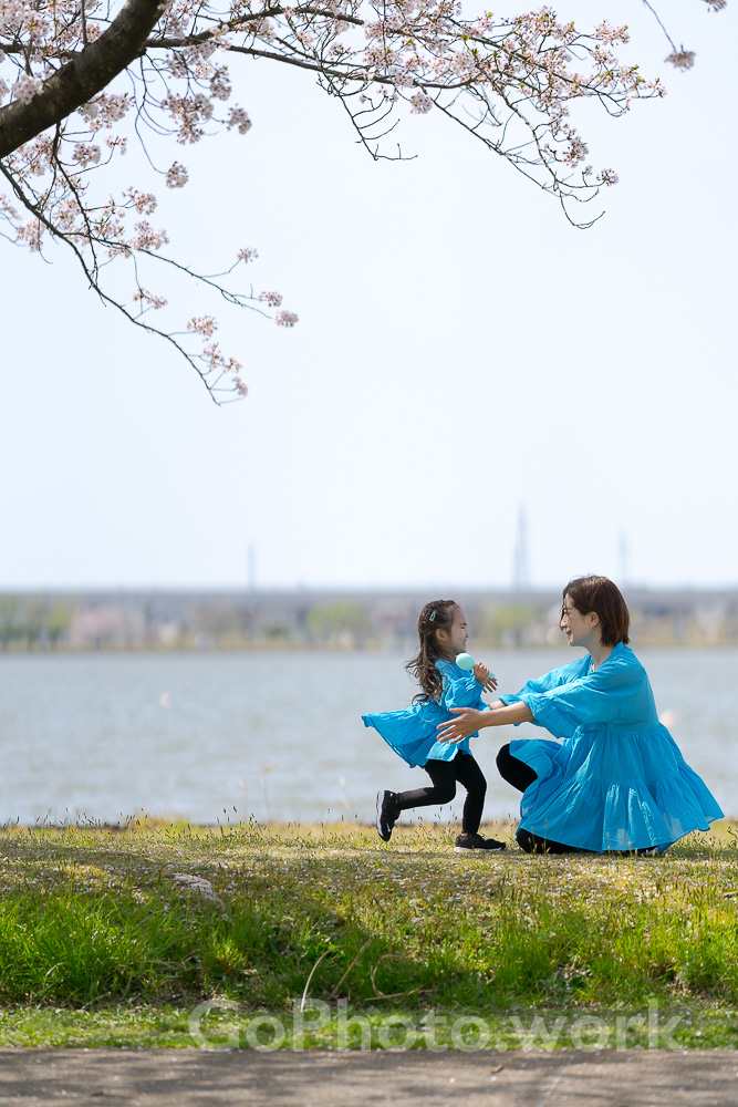 桜の木の下で抱っこする親子