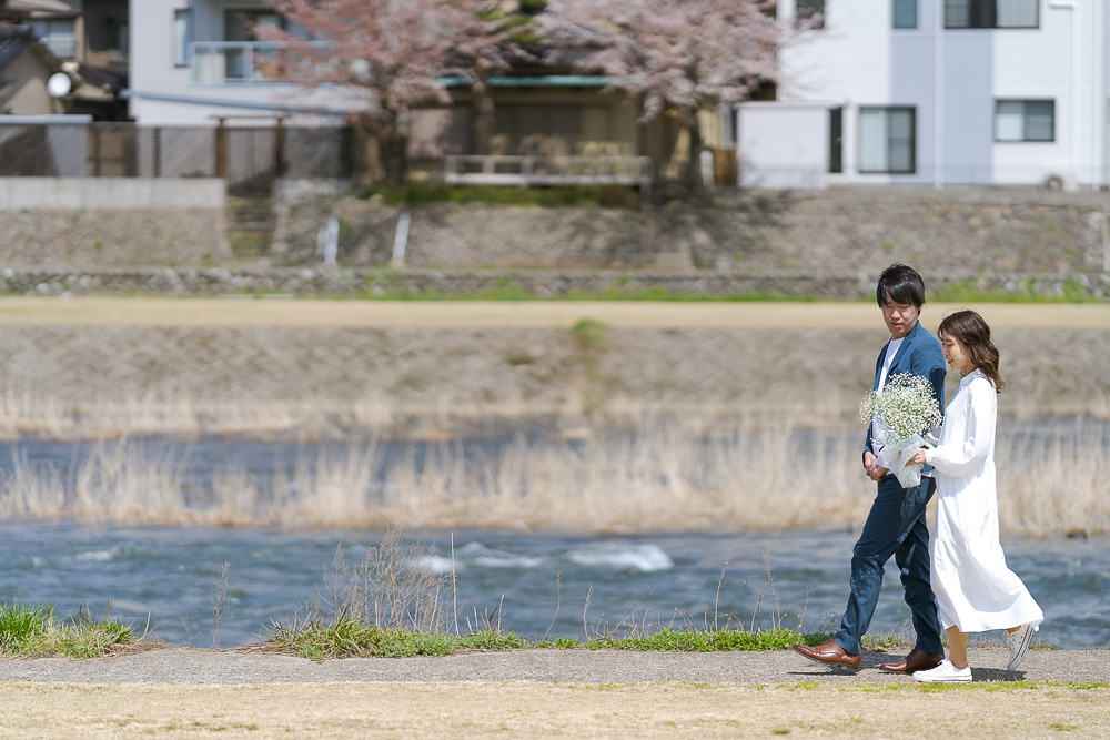 川辺を歩く新郎新婦
