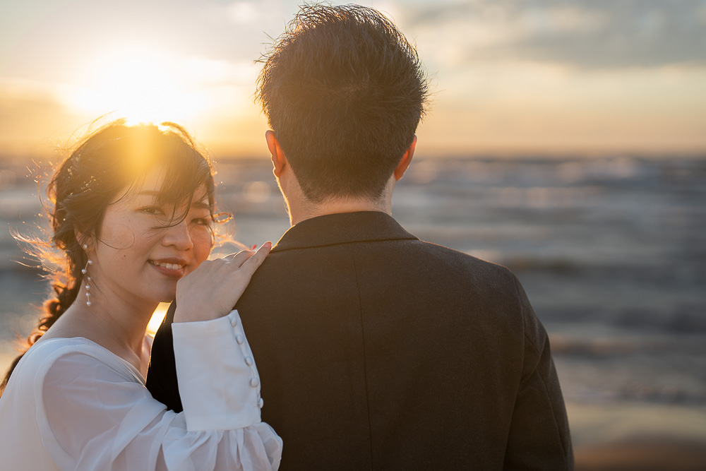 夕陽の海辺の新郎新婦