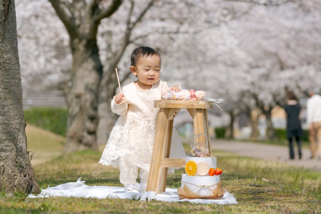 桜の樹の下で微笑む赤ちゃん