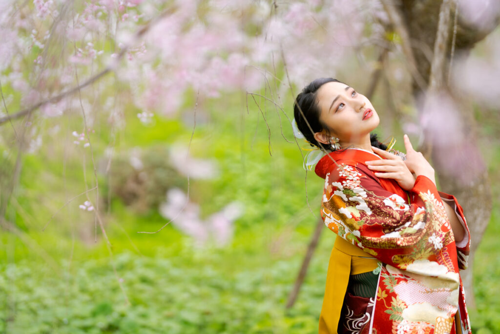 桜の下でポーズをとる卒業袴の女性