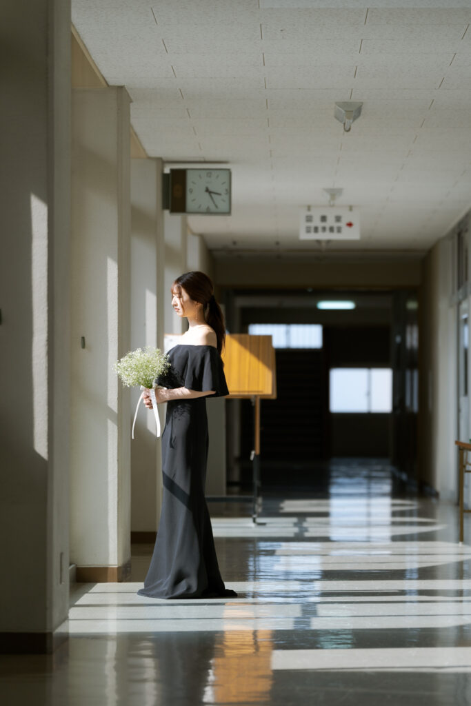 学校の廊下で日差しを浴びる新婦