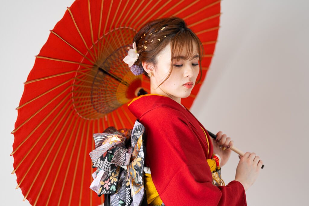 赤い和傘をも持った振り袖の女性