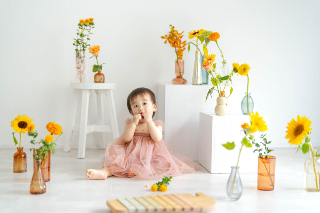 ピンクドレスの赤ちゃんと花が彩る可愛いフォトシーン