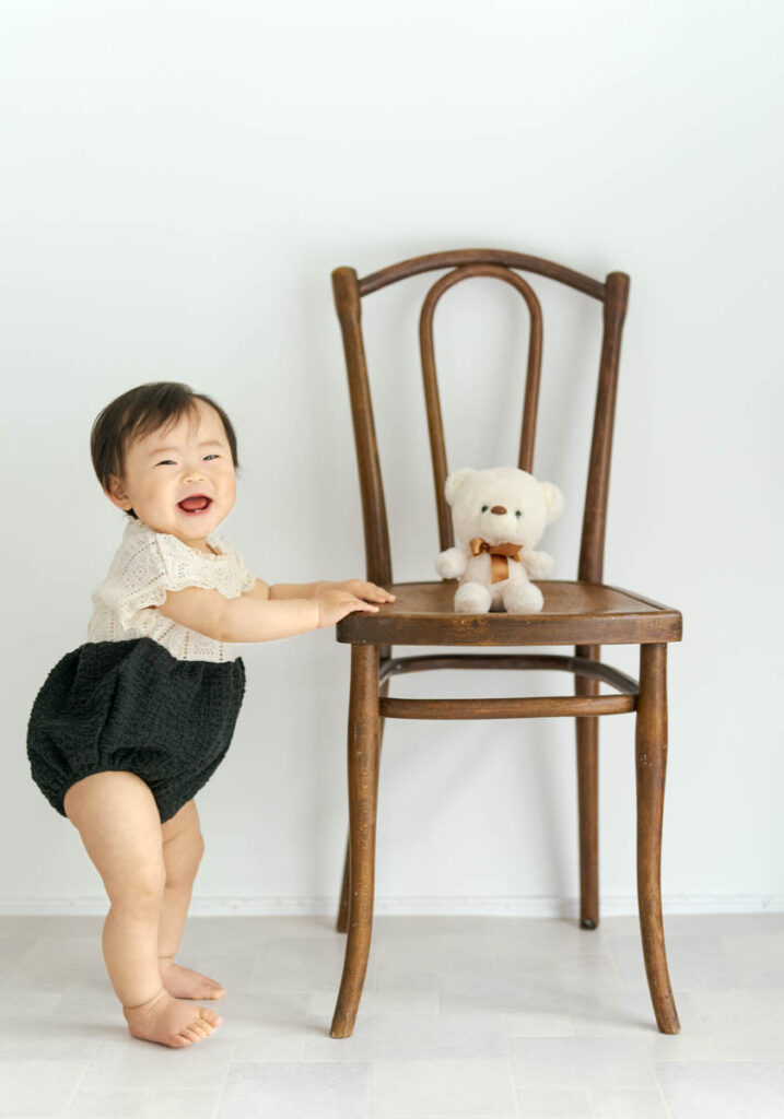 笑顔の赤ちゃんと木の椅子、かわいいテディベアの温かい瞬間