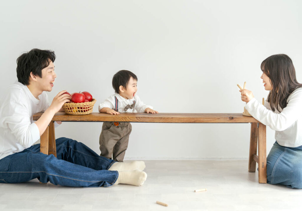 家族が木のテーブルで笑顔とリンゴを囲む温かいひととき