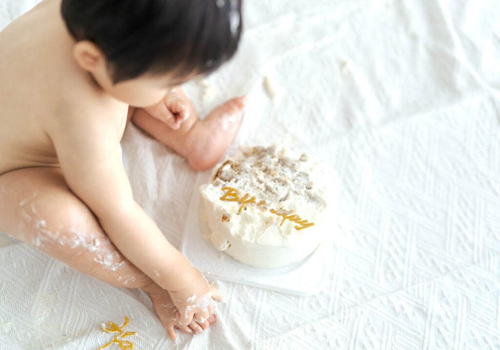 赤ちゃんのバースデーケーキスマッシュを楽しむかわいい瞬間