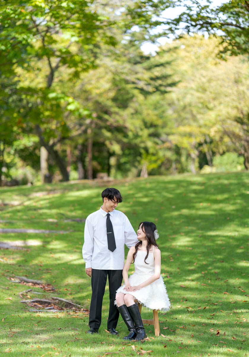 秋の公園で微笑み合う若いカップル