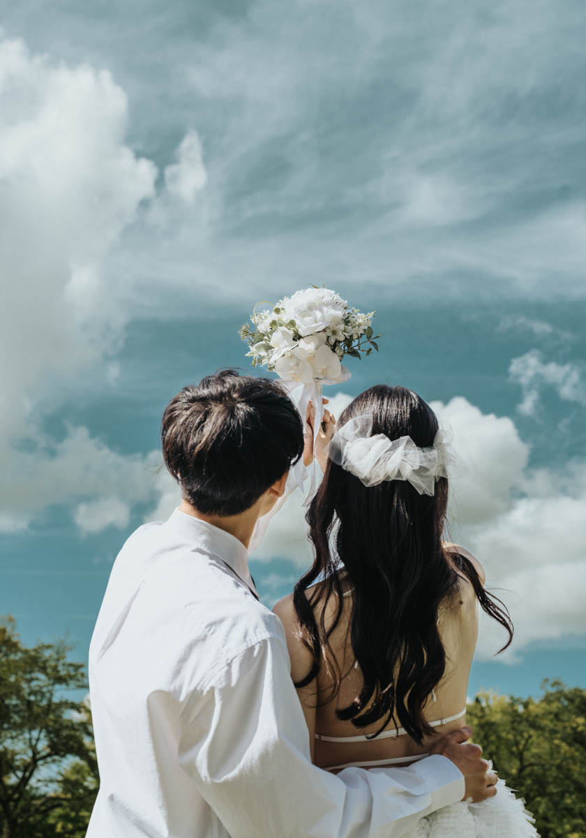 青空の下で抱き合う新郎新婦の幸せな瞬間