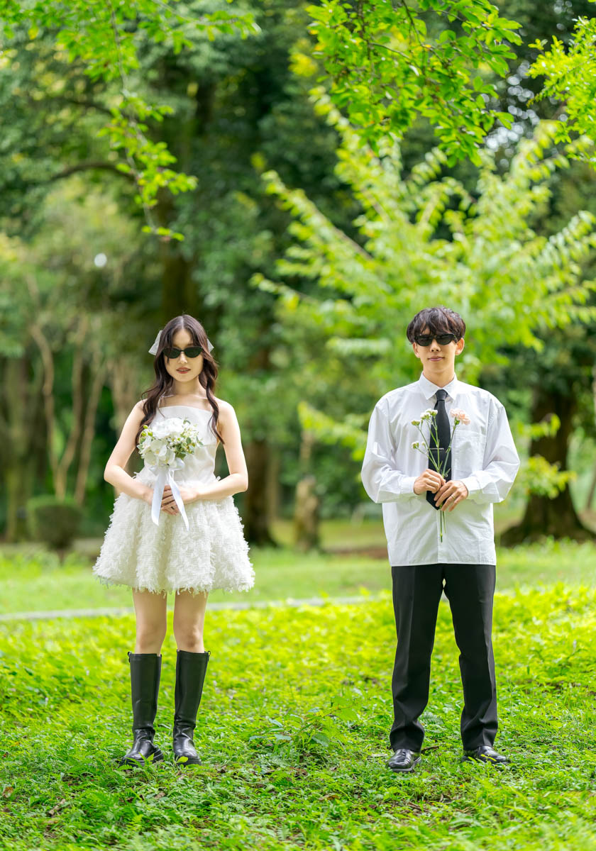 緑の公園で花を持つおしゃれな男女