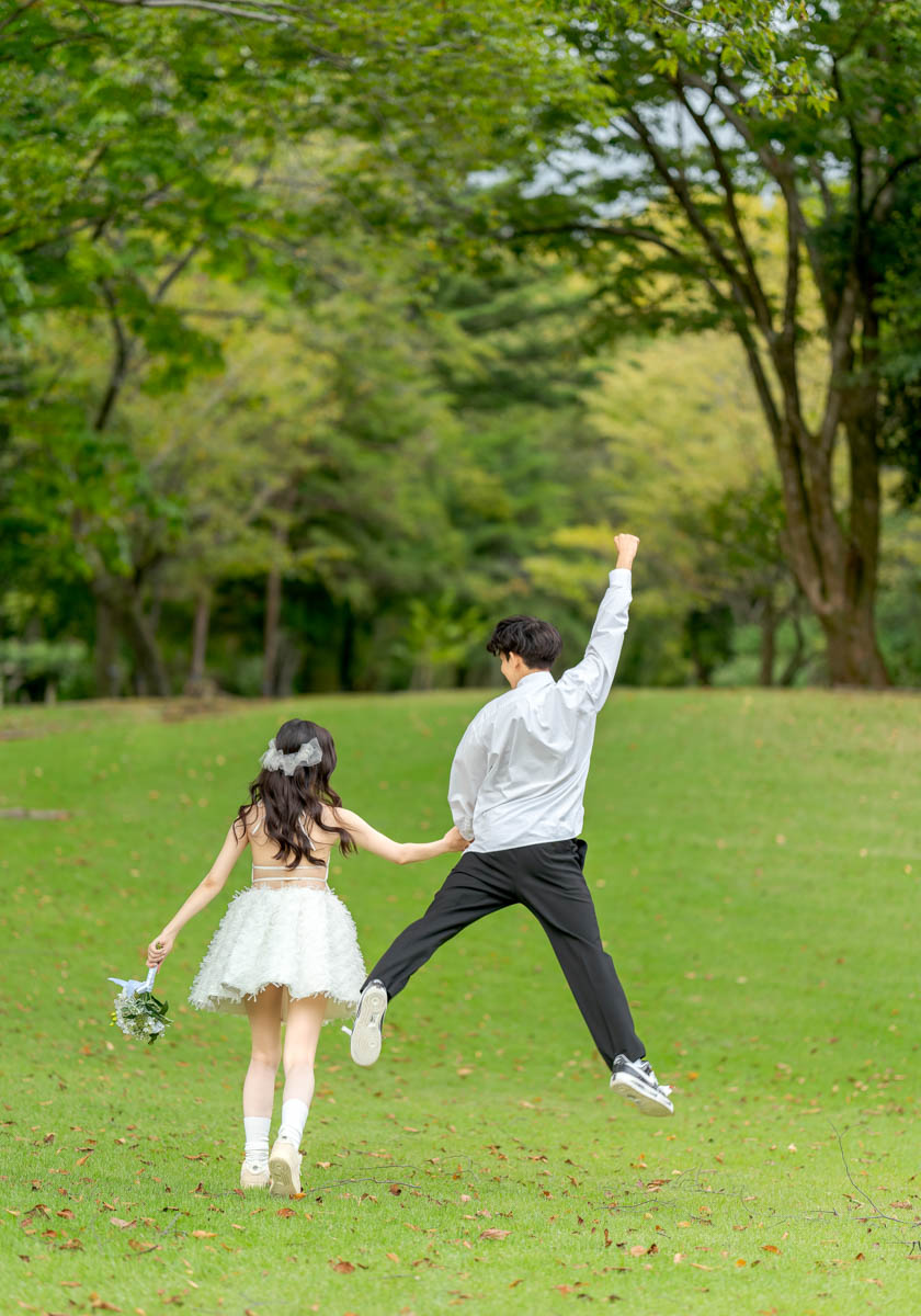 夏の公園で手を取り合う笑顔の花嫁と新郎