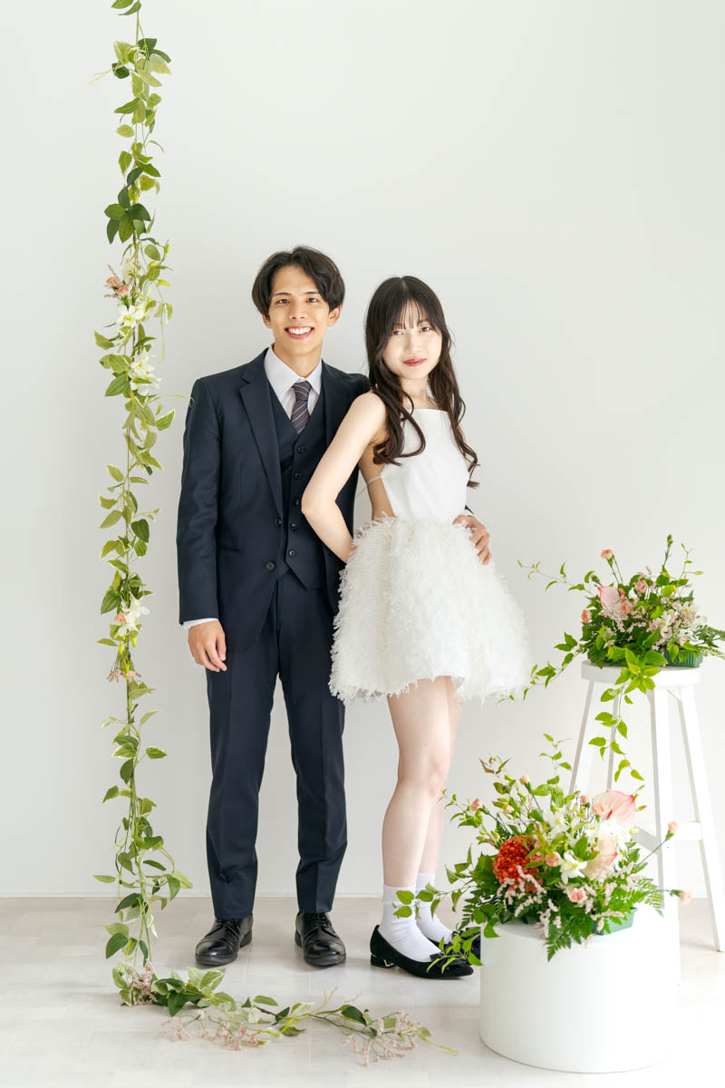 白い背景で微笑むカップルのナチュラルウェディングフォト