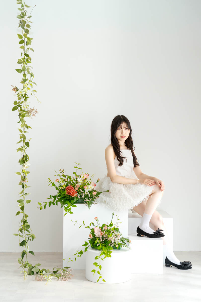 白いドレスの女性と華やかな花々が彩る優雅なポートレート