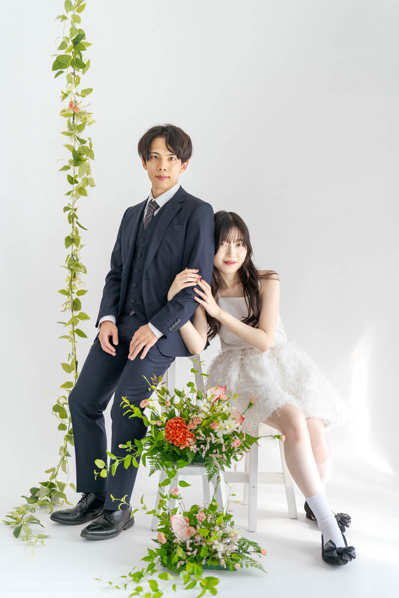 白背景で花に囲まれたエレガントなカップルのロマンティックポートレート