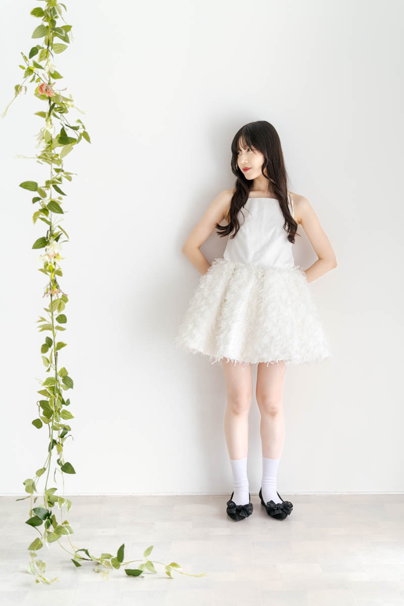 白いドレスの女性と緑のガーランドが調和するエレガントなポートレート