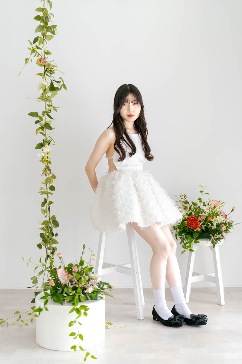 白いドレスの女性が花と共に座る上品で美しいポートレート