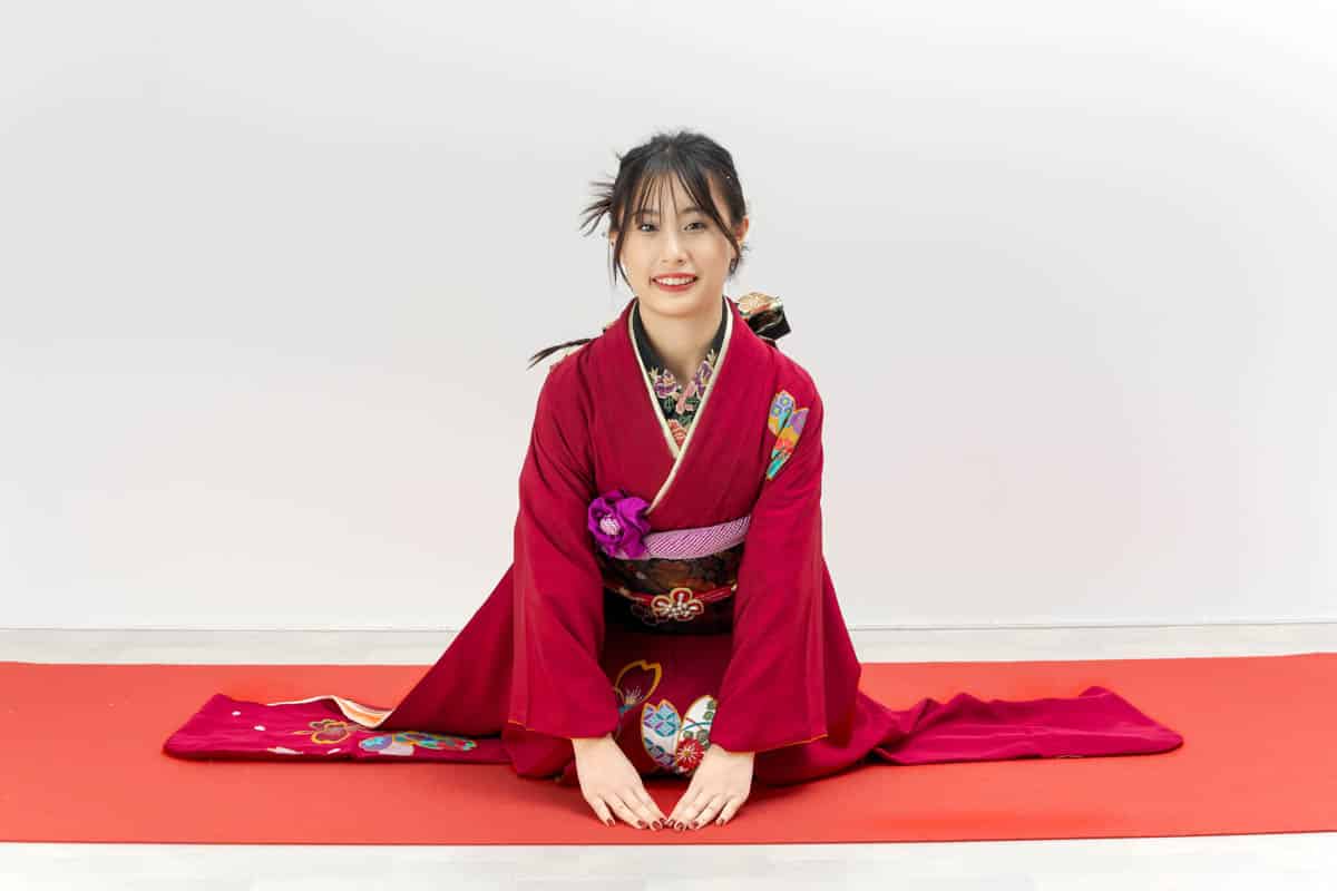 赤い着物でスプリットする笑顔の女性と和の美しさ