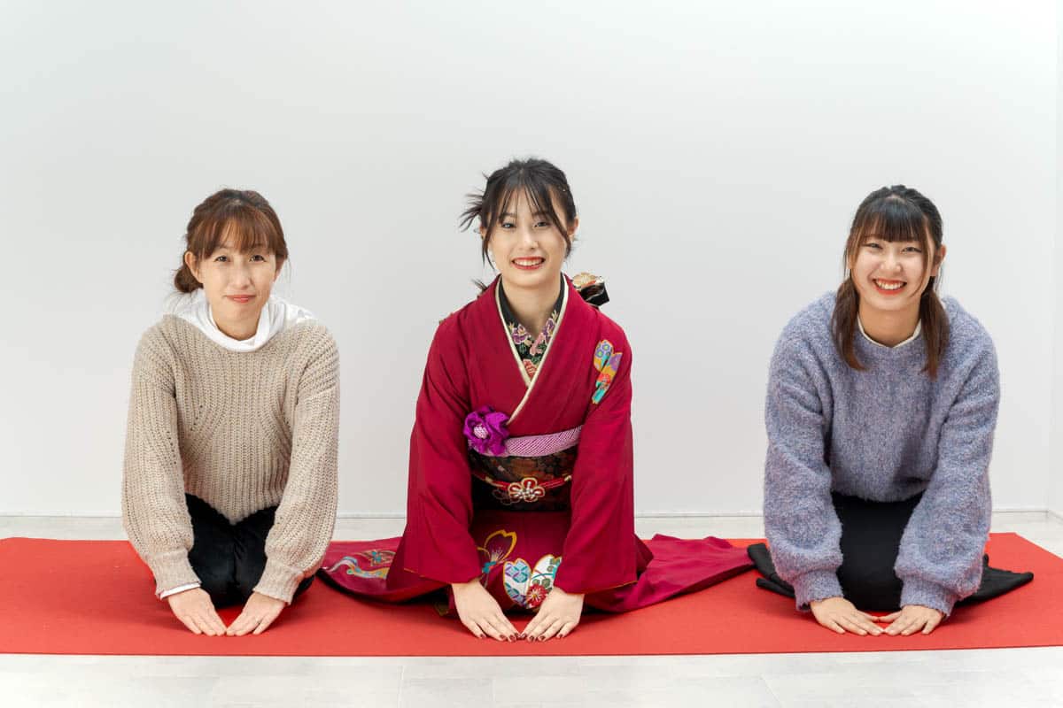 赤い着物の女性と友人が微笑む和モダンな記念写真